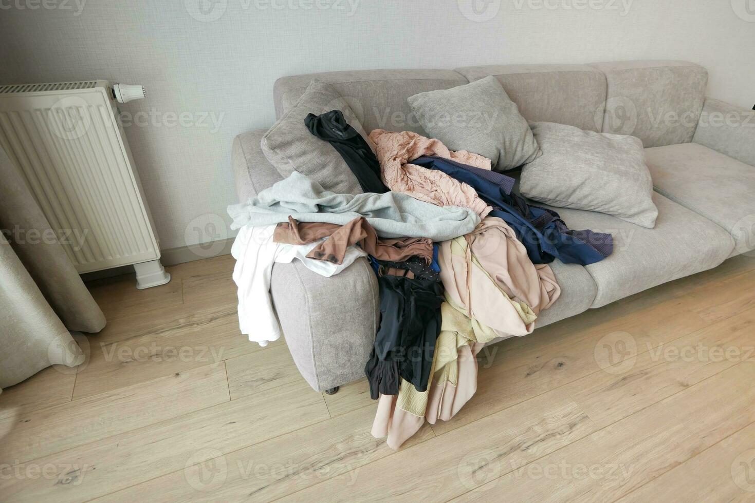 rörig kläder på soffa på Hem foto