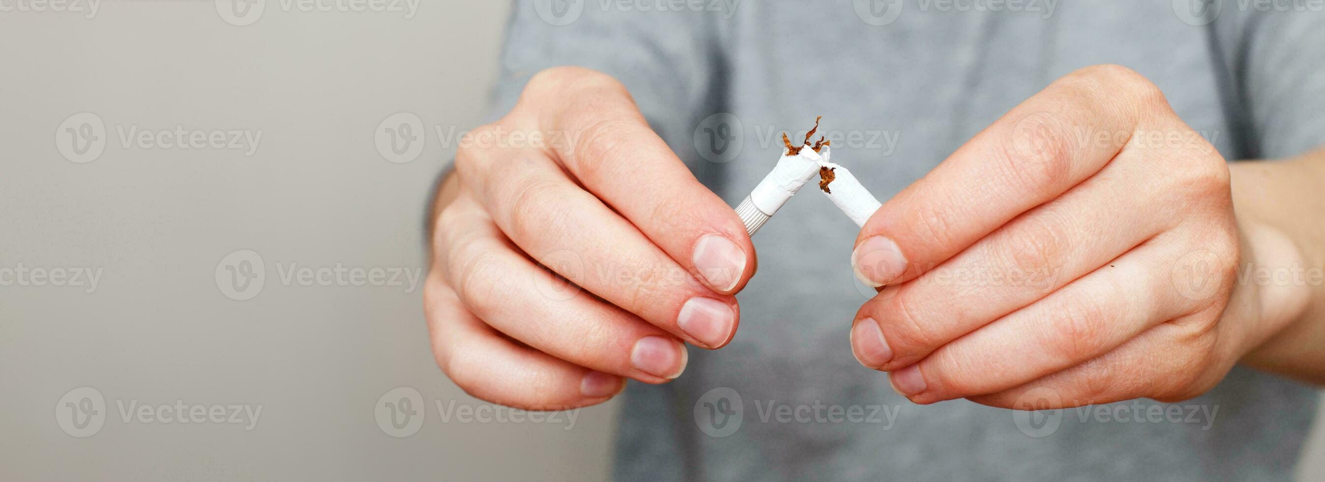 ung kvinna innehav bruten cigarett i henne händer stäng.banner foto