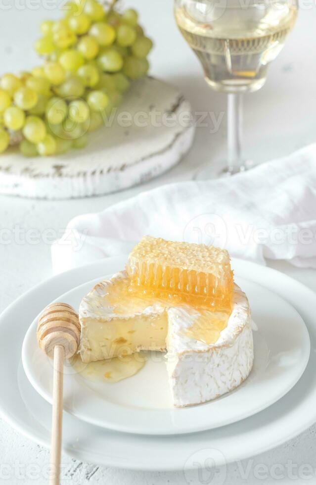 Camembert med honung, vindruvor och vit vin foto