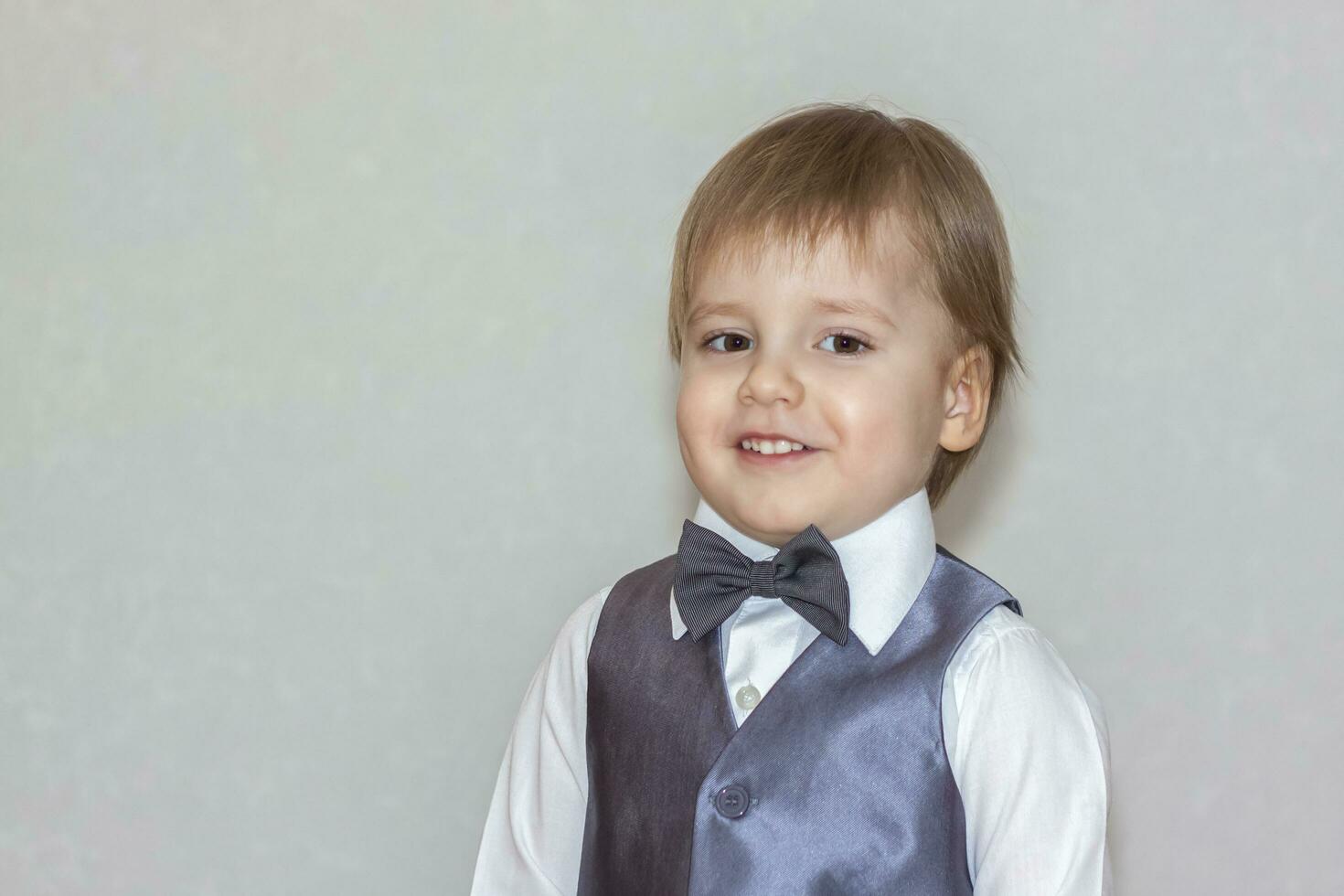 de begrepp av de hjärtans dag tema. porträtt av en söt pojke i en kostym med en rosett slips. foto