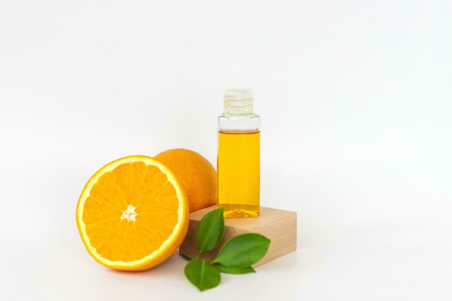 orange olja för de kropp. orange på en trä- piedestal på en vit bakgrund. organisk spa kosmetika med ört- Ingredienser. foto