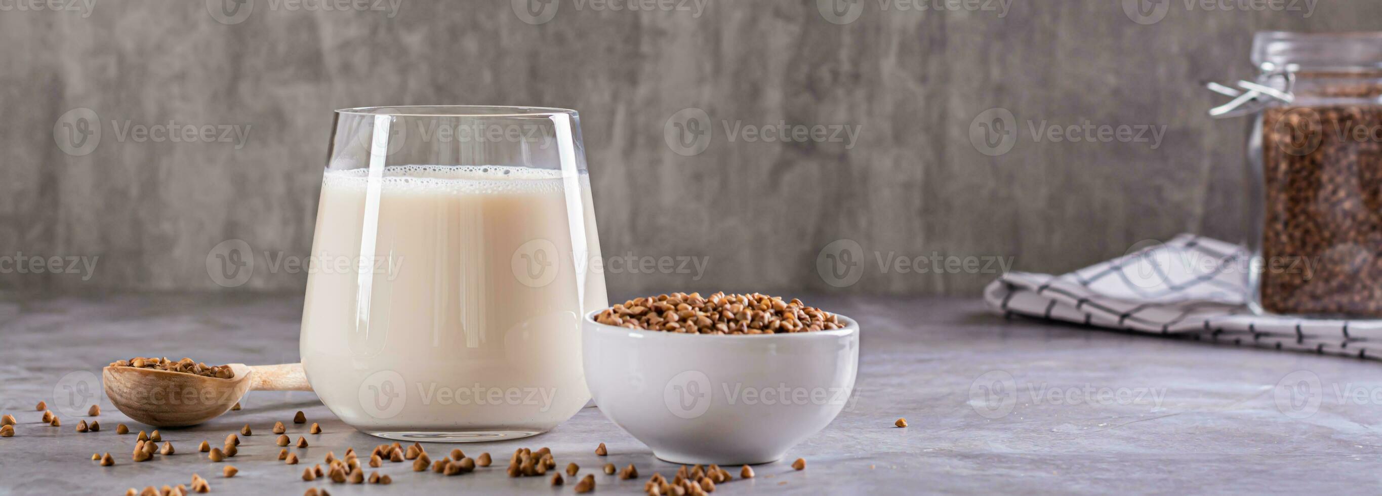 vegan mjölkfritt bovete mjölk i en glas och spannmål i en skål på de tabell webb baner foto