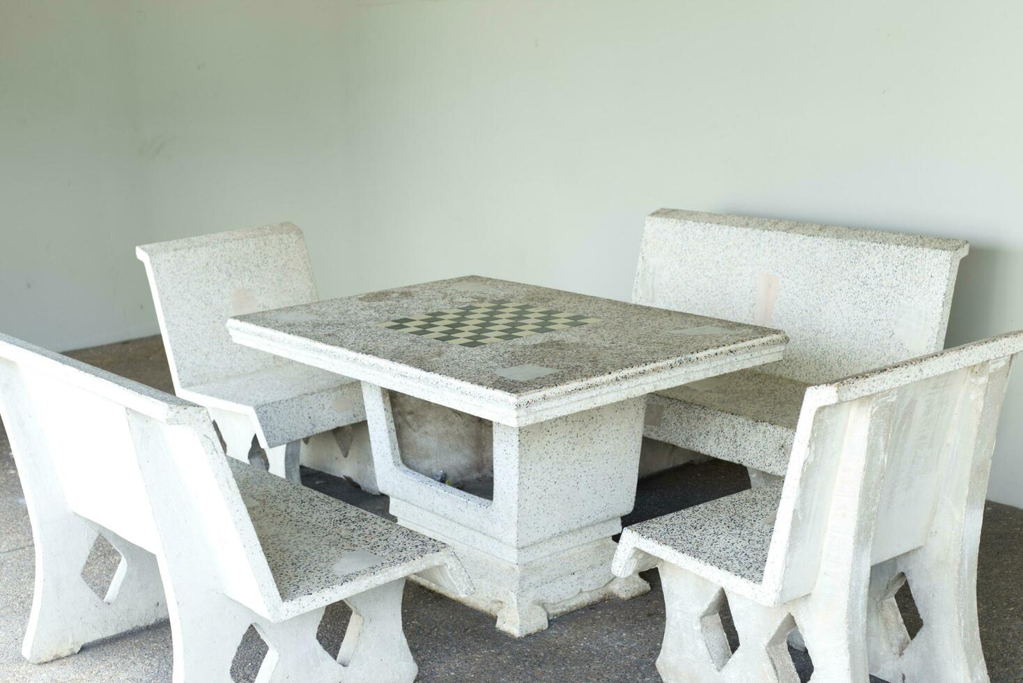 vit cement och marmor tabell med schack tabell och 4 stol uppsättning i de trädgård foto
