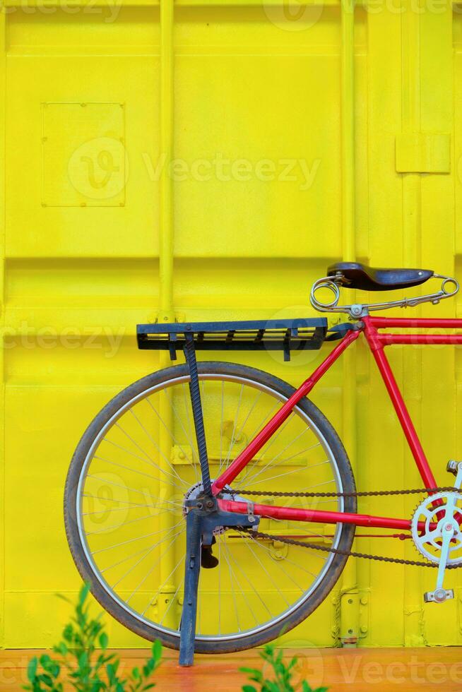 cykel på trä golv mot behållare gul vägg foto