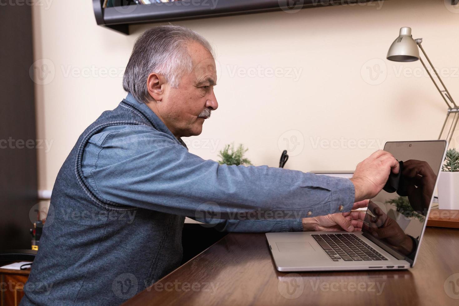 manhänder som rengör bärbar datorskärm med trasa foto