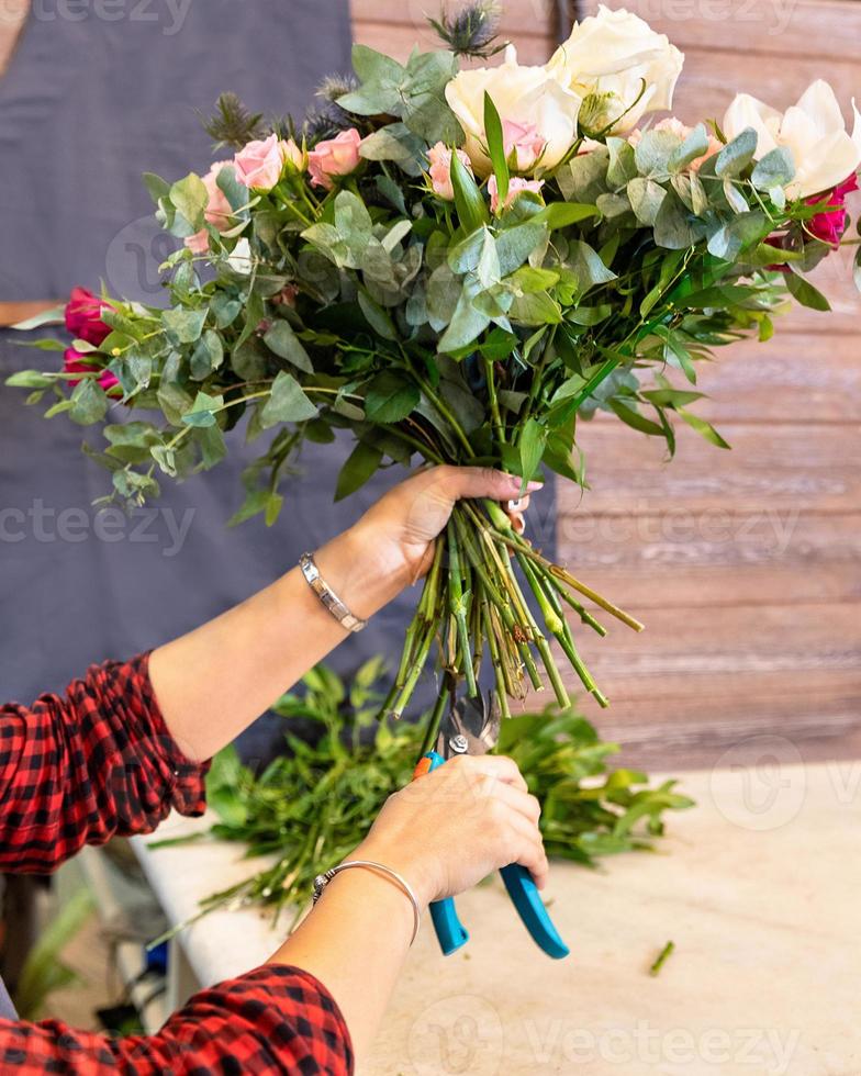 blomsterhandlare kvinna gör blombukett i affären foto