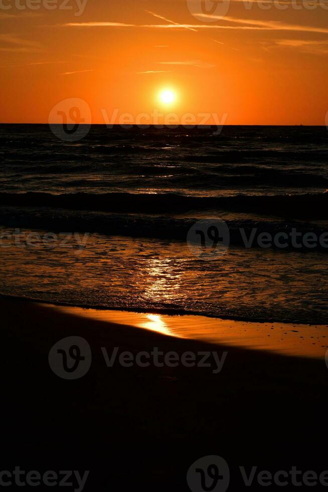 orange solnedgång på de strand av de baltic hav i polen foto