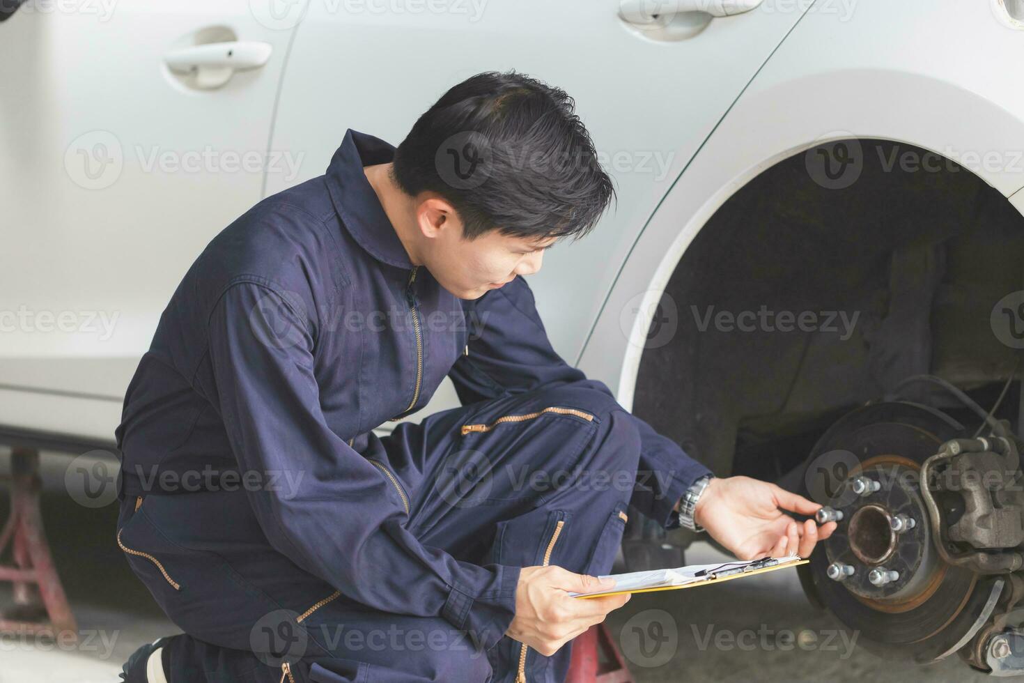 bil mekaniker reparatör med en checklista, tekniker kontroll modern bil på garage, bil reparera och underhåll begrepp foto
