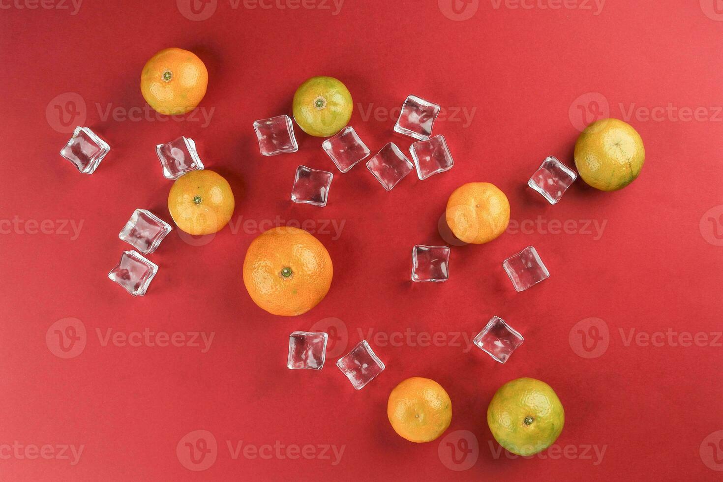 små gul grön mandarin is kub orange på röd Färg papper bakgrund kopia Plats för text foto