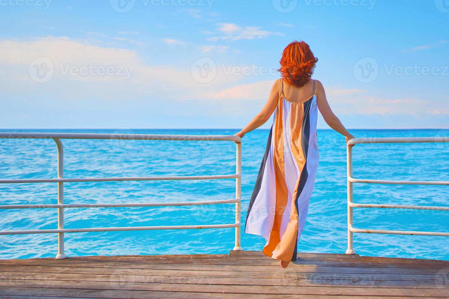 kvinna på pir med havsbakgrund foto