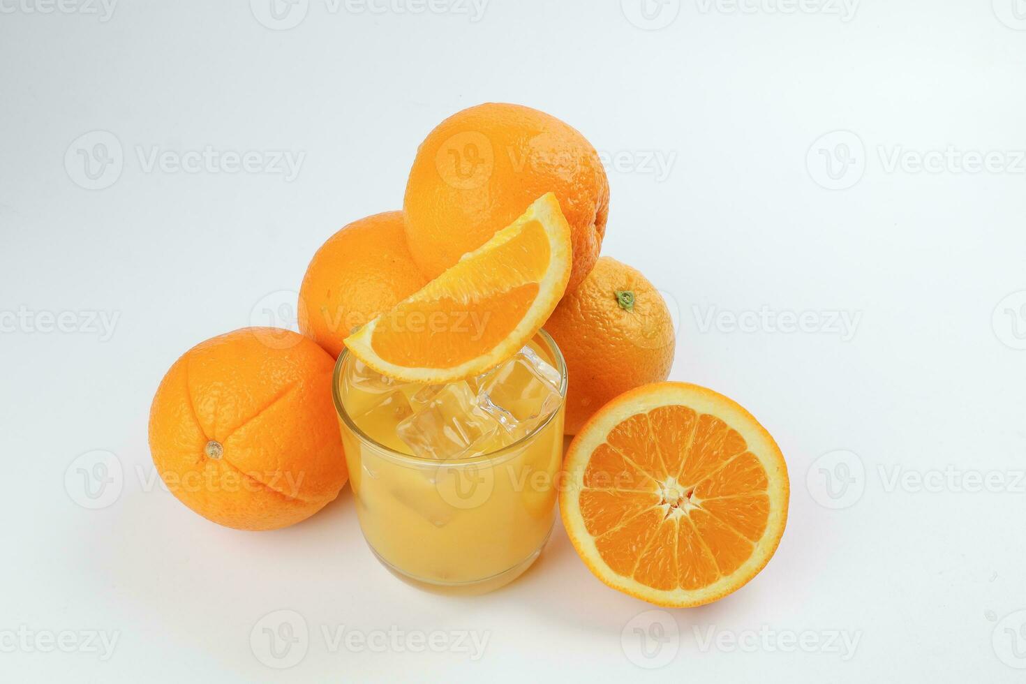 färsk gul orange juice i glas med hela skivad orange frukt och is kub på vit bakgrund foto