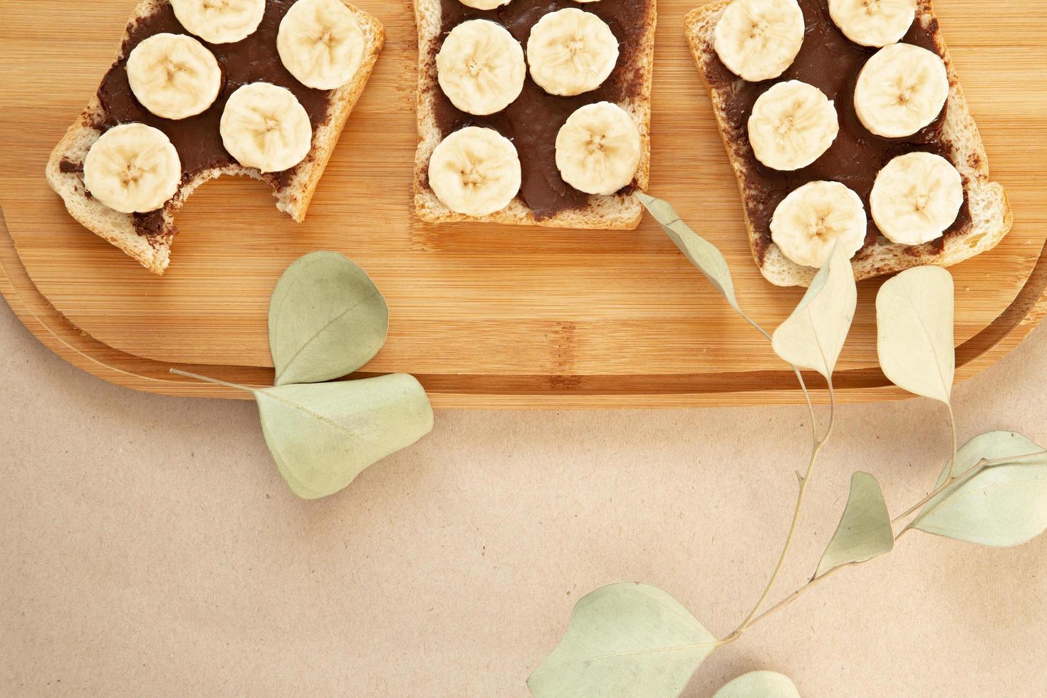 tre rostat bröd med bananvitt smet med chokladsmör foto