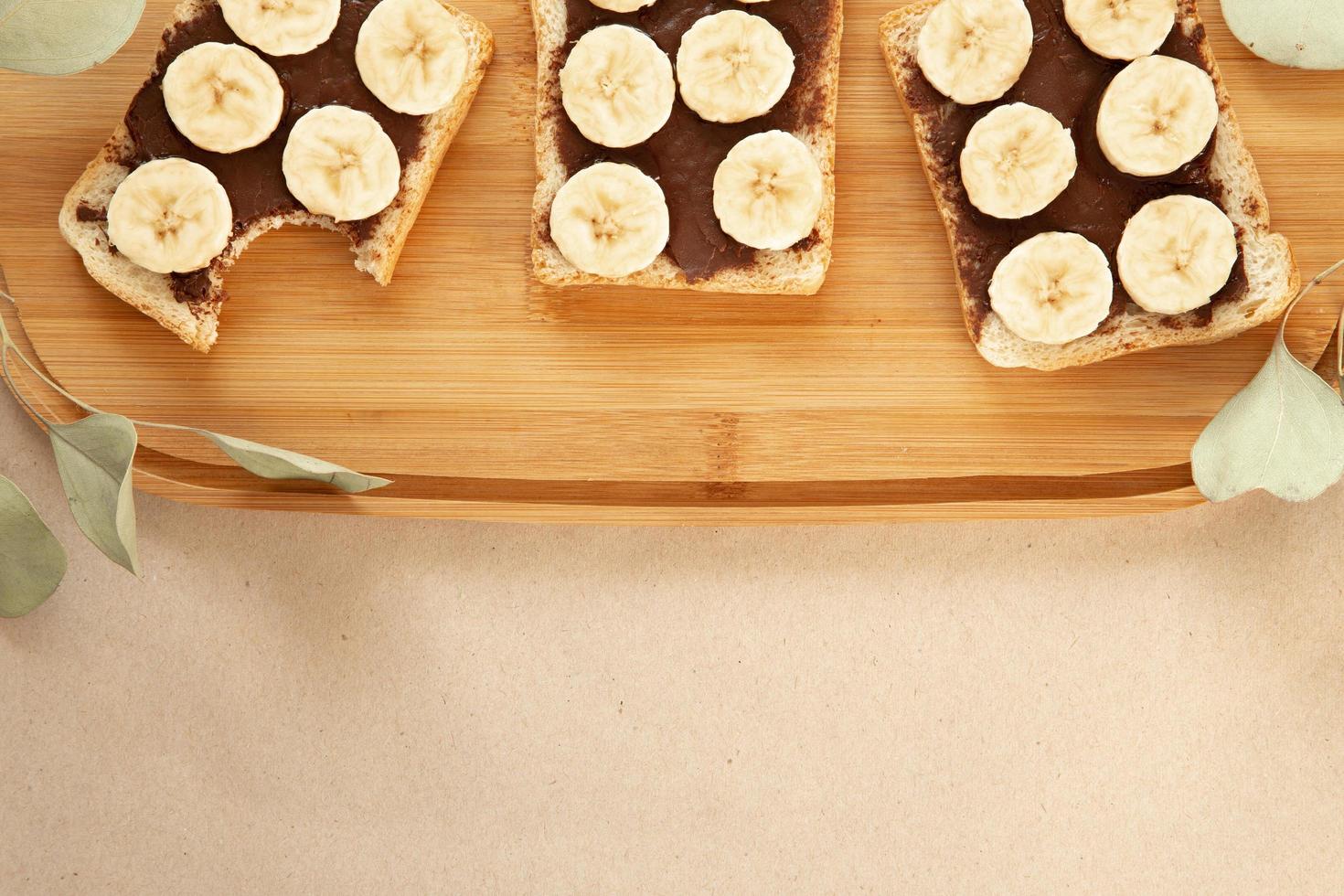 tre rostat bröd med bananvitt smet med chokladsmör foto