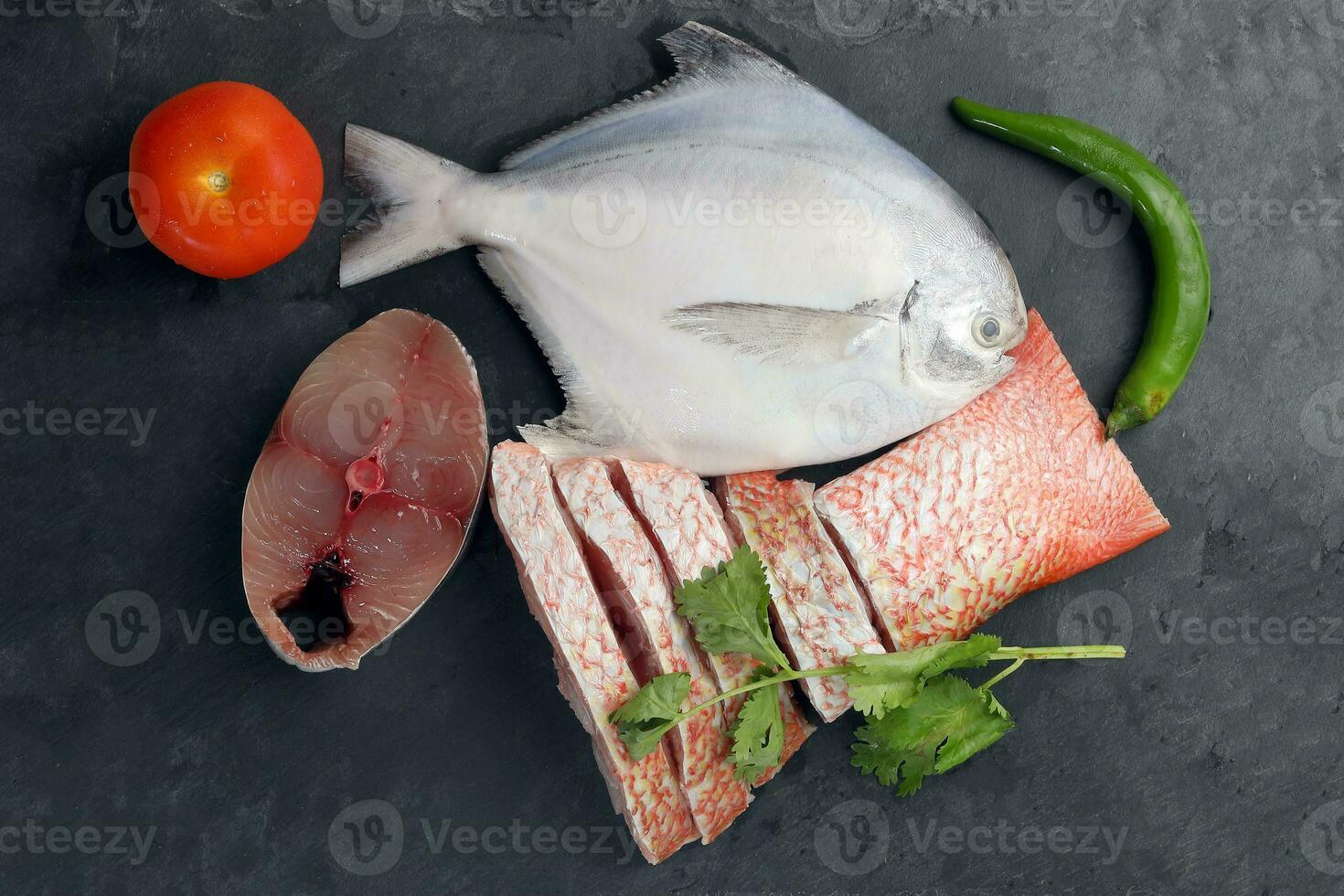 vit pomfret spanska makrill röd snapper fisk rengöras avkalkat deguterad skivad filea bitar på svart marmor skiffer bakgrund foto