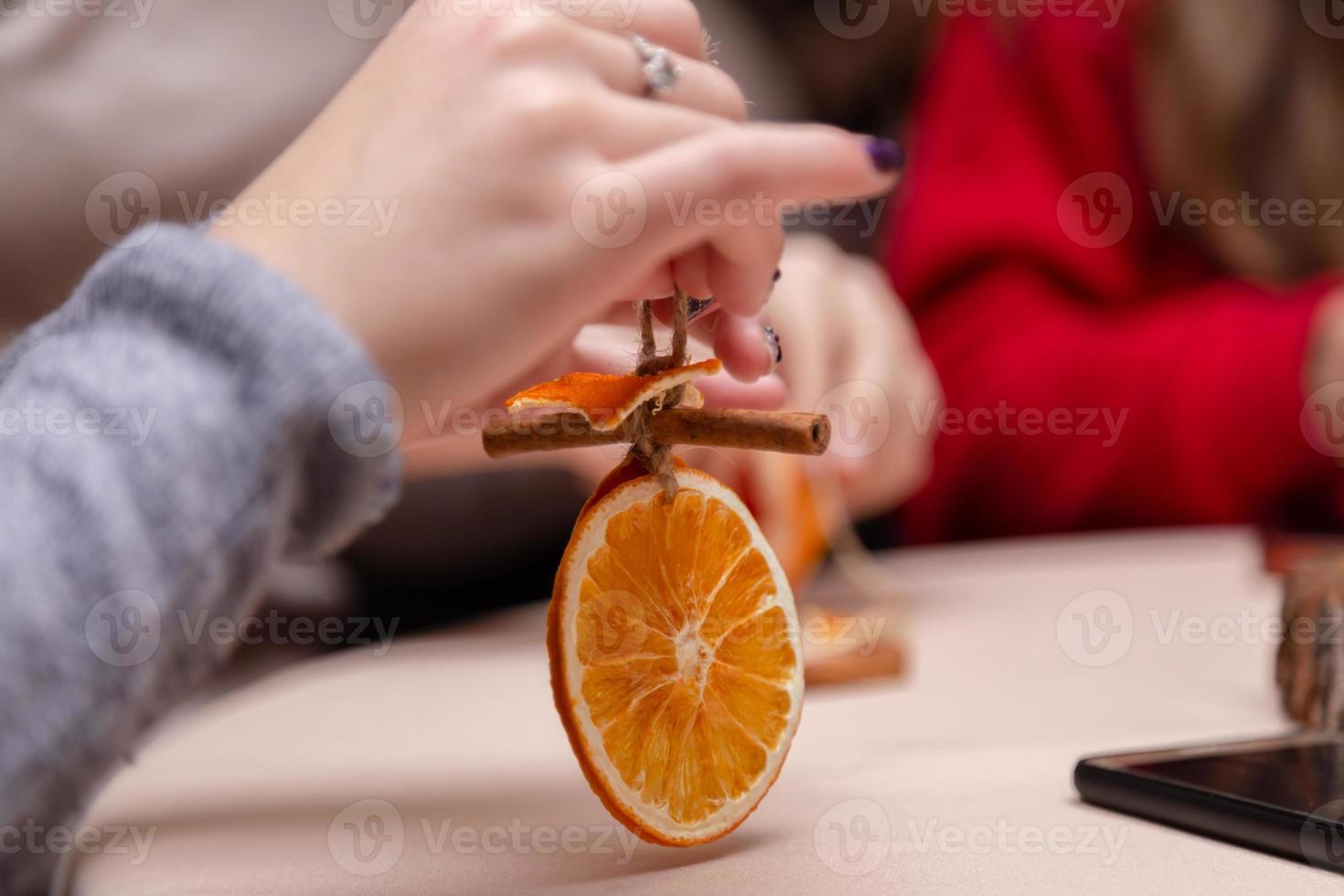 kvinnor hand gör dekorationer från torkade apelsiner foto