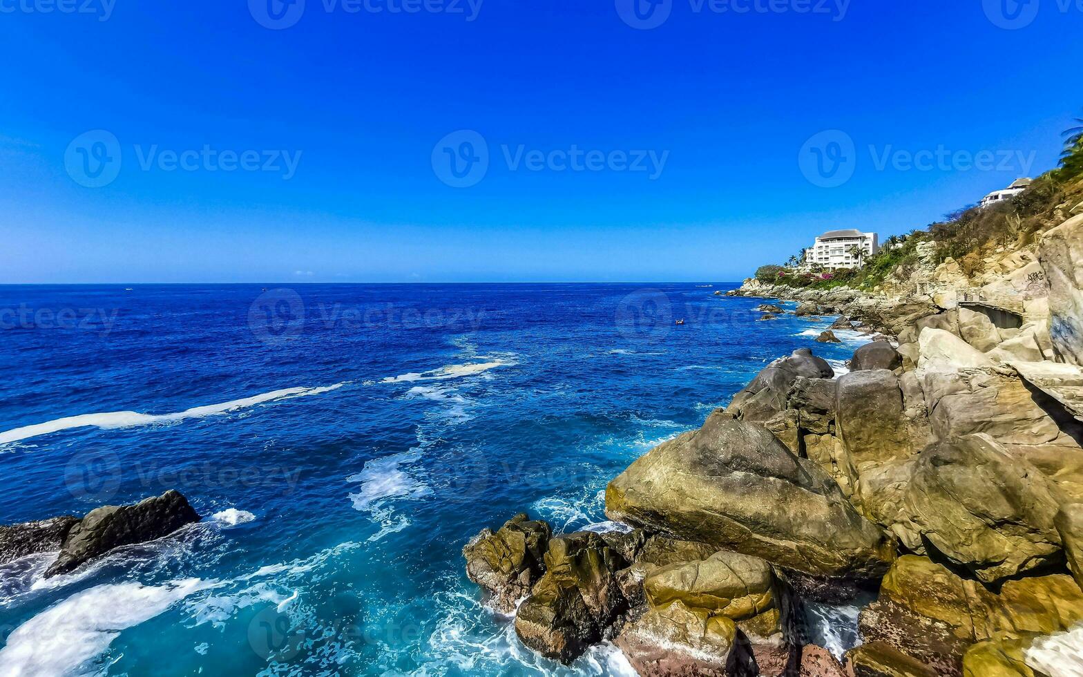 surfare vågor turkos blå vatten stenar klippor stenblock puerto escondido. foto