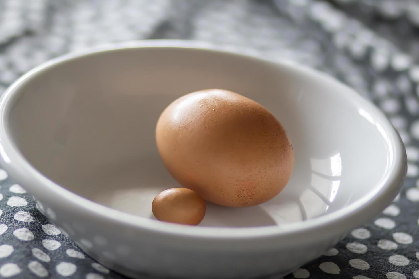 litet ägg och stort ägg i en skål foto