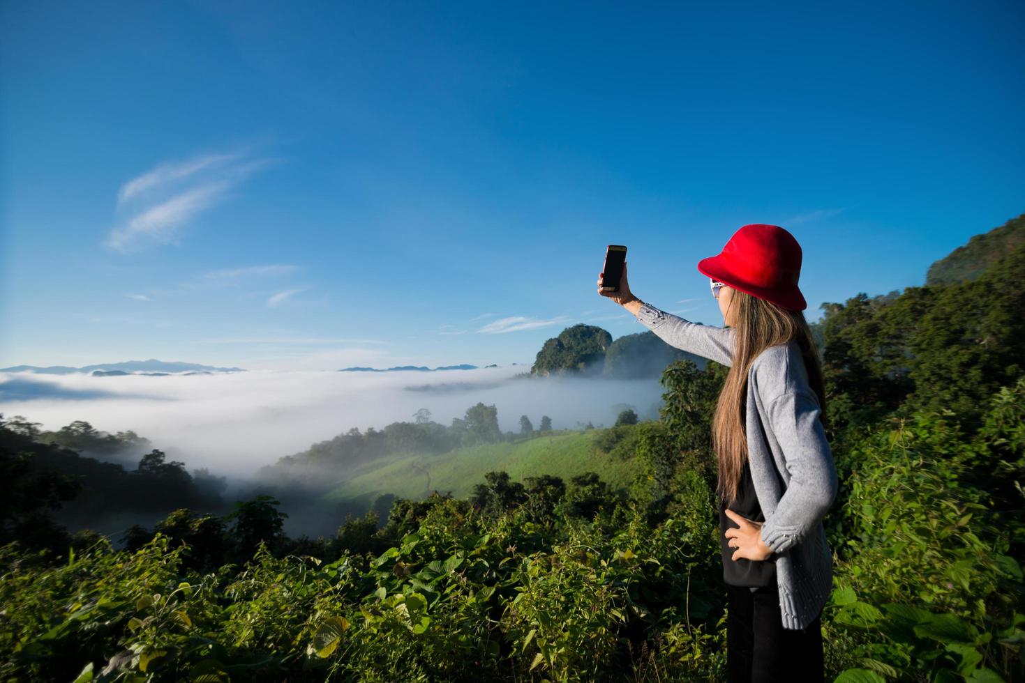 kvinna som tar selfiefoto i berget med dimma i bakgrunden, landskap i Mae Hong Son-provinsen, Thailand foto