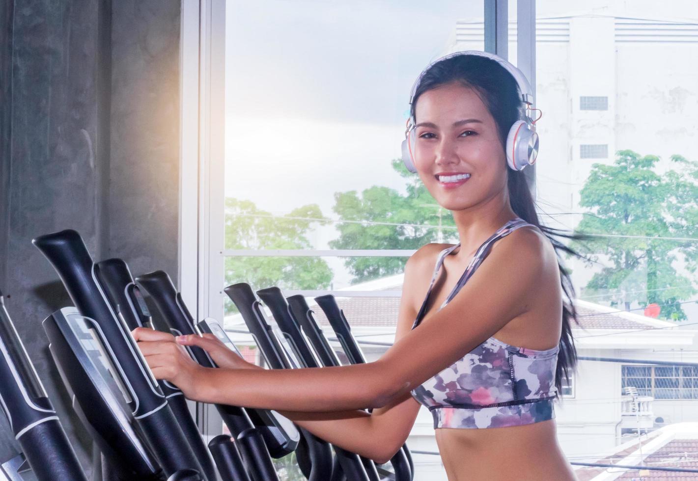 vacker asiatisk kvinna tränar i ett gym foto