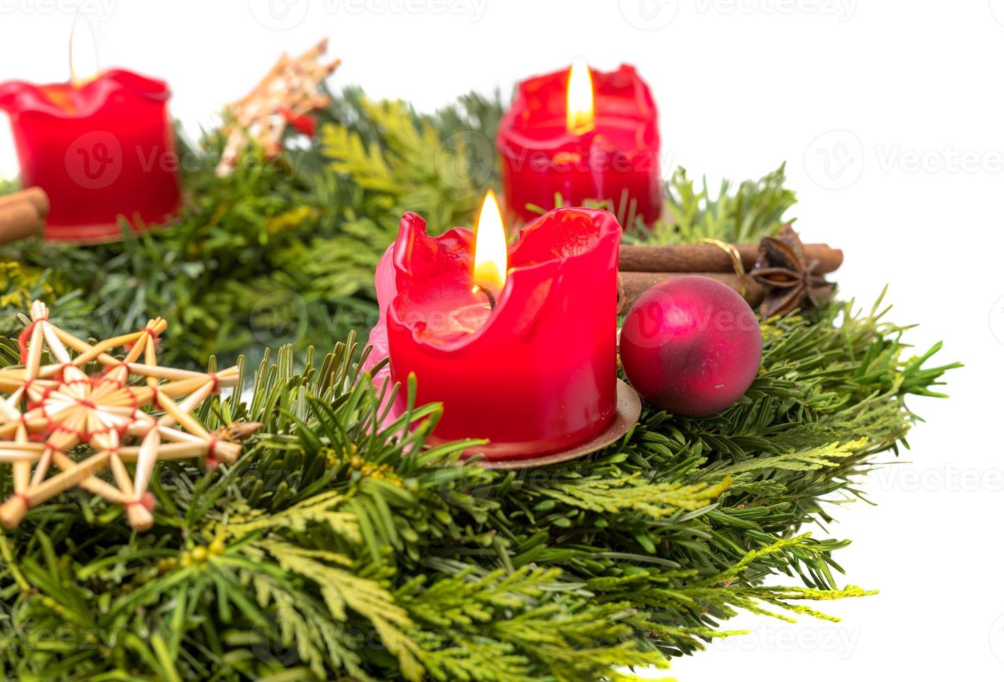 dekorerad adventskrans av grangrenar med brinnande röda ljus foto