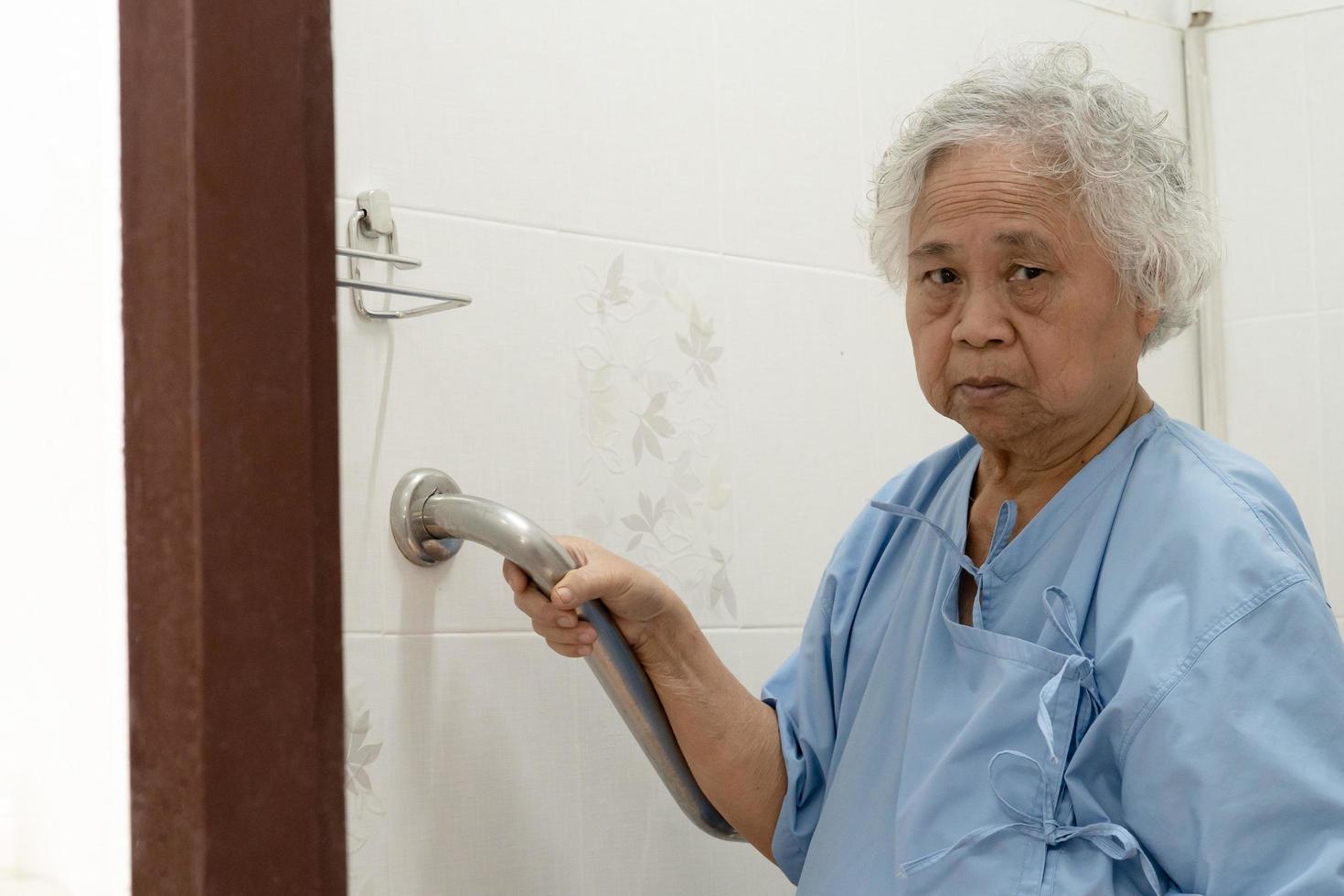 asiatisk äldre eller äldre gammal dam kvinna patienttoalett badrum handtag säkerhet i vårdavdelningen foto