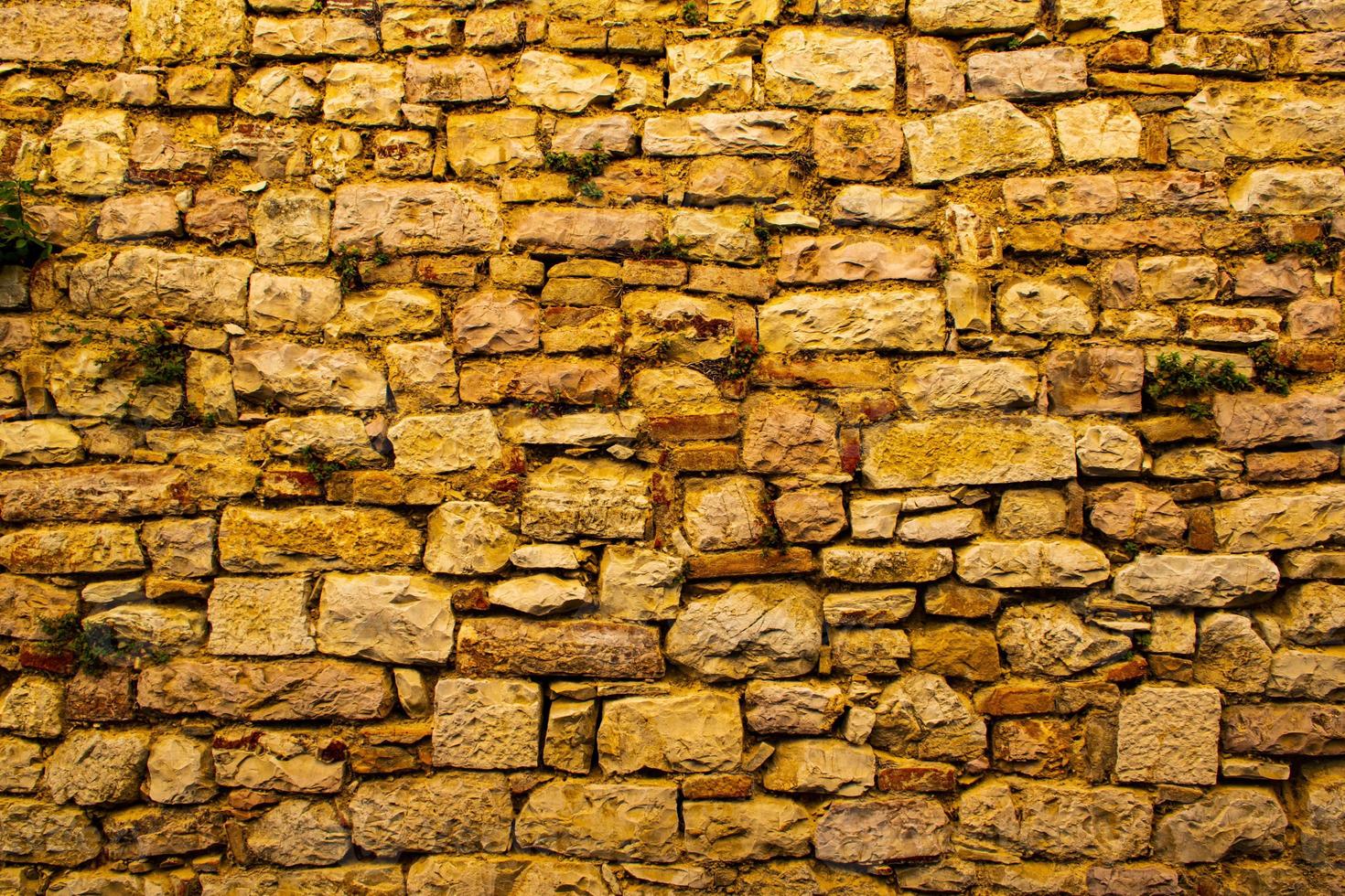 forntida mur av stenar och murbruk med tegelstenar foto