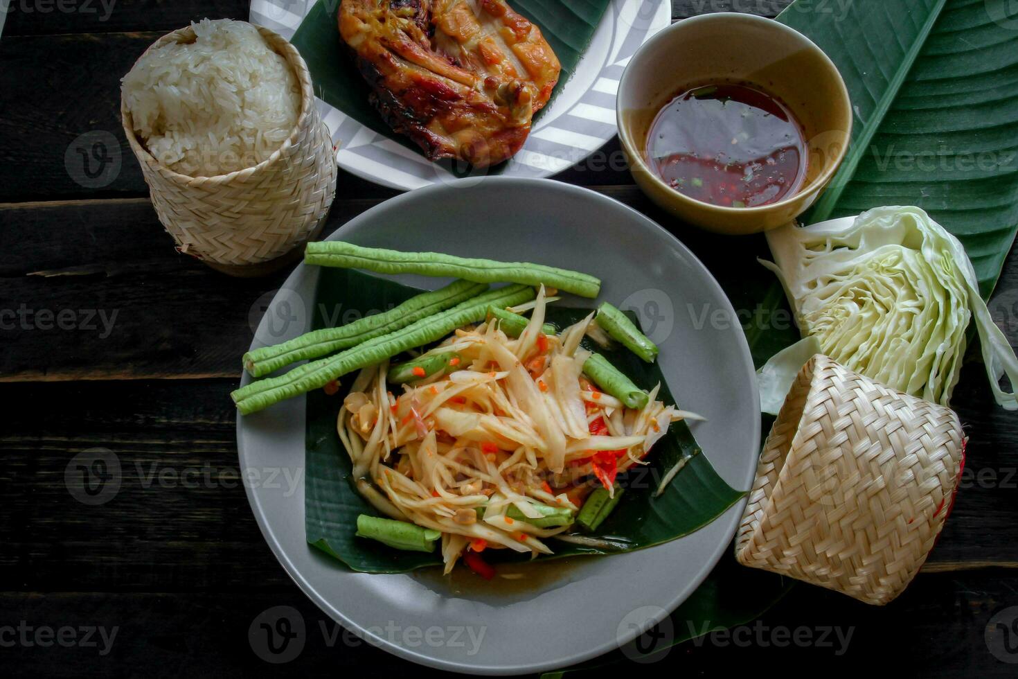 thai mat maträtt både i thailand och Asien papaya sallad eller som vi ring upp den somtum är kompletteras med grillad kyckling och klibbig ris med färsk röror. eras på de svart trä- tabell. foto