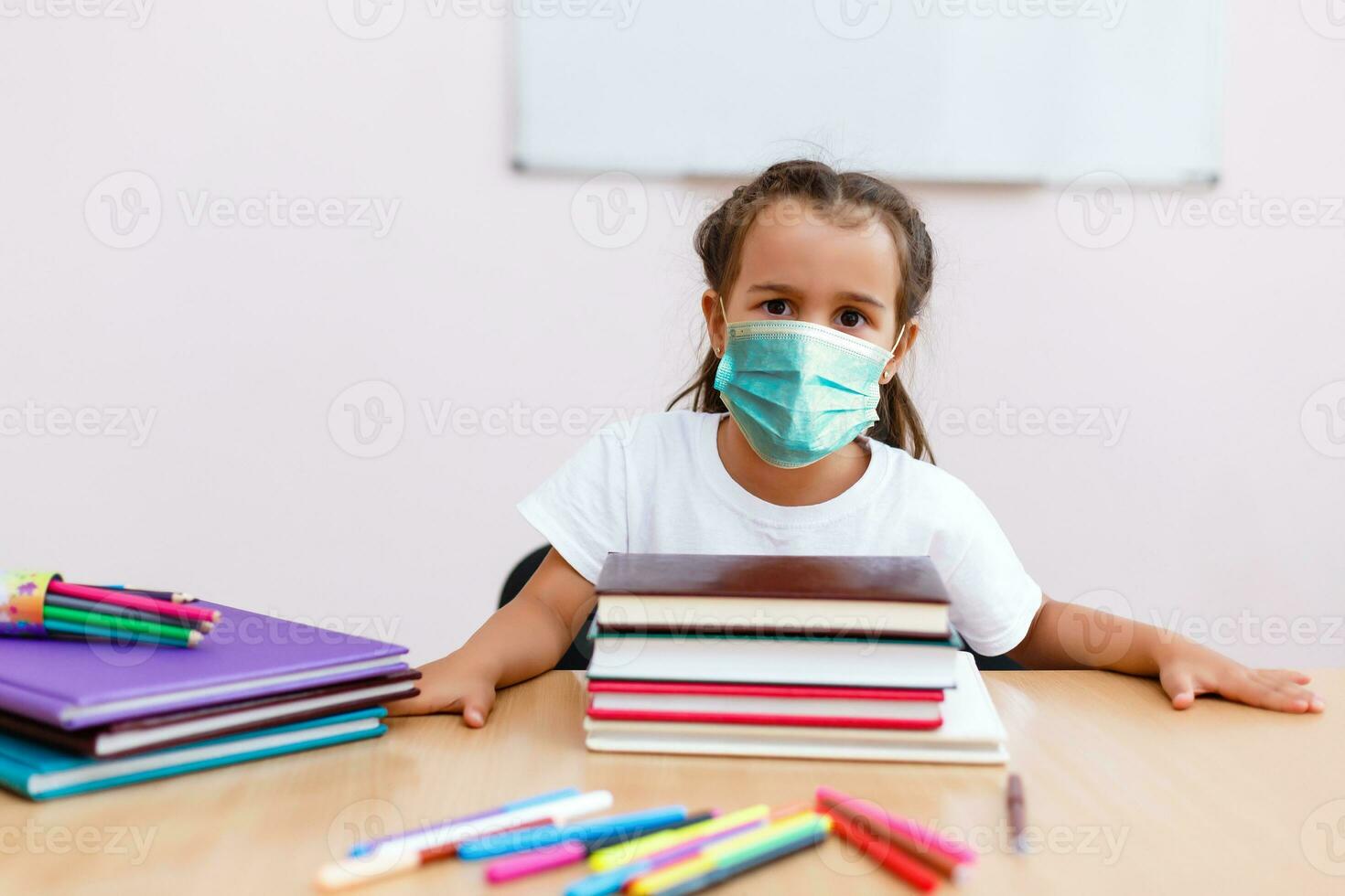 barn flicka studerande bär skyddande medicinsk ansikte mask i skola, epidemi, spridning av coronavirus, covid19, skol med mask till förhindra korona virus infektion, stridande de utbrott av covid-19 foto