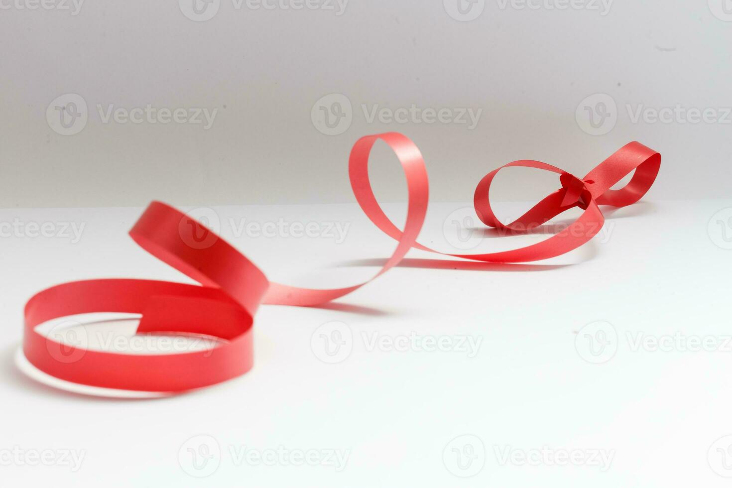 glänsande rött satängband på vit bakgrund foto