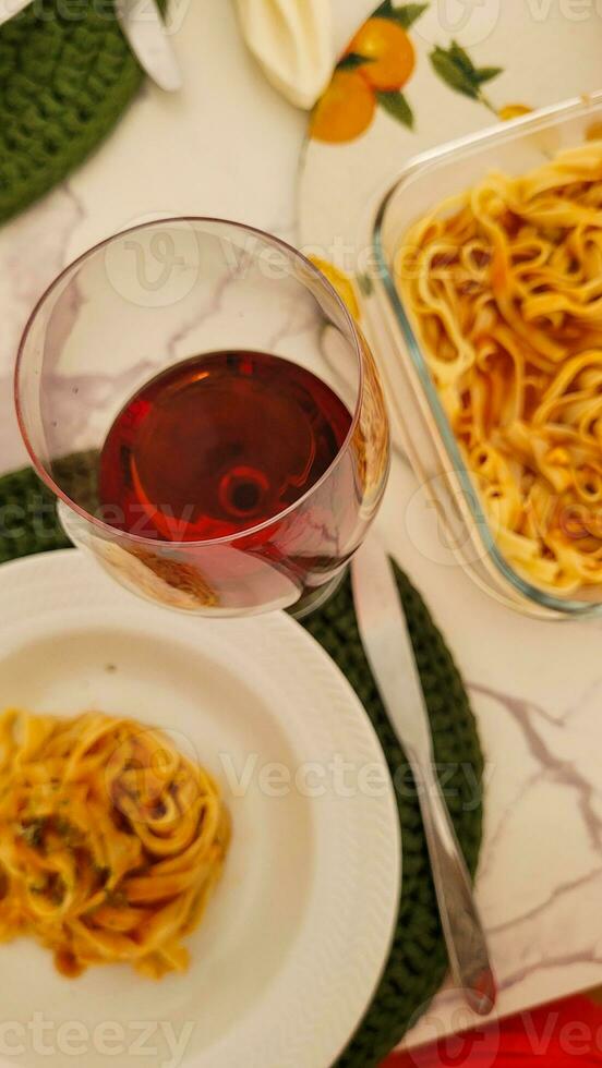 middag med pasta och glas av röd vin foto