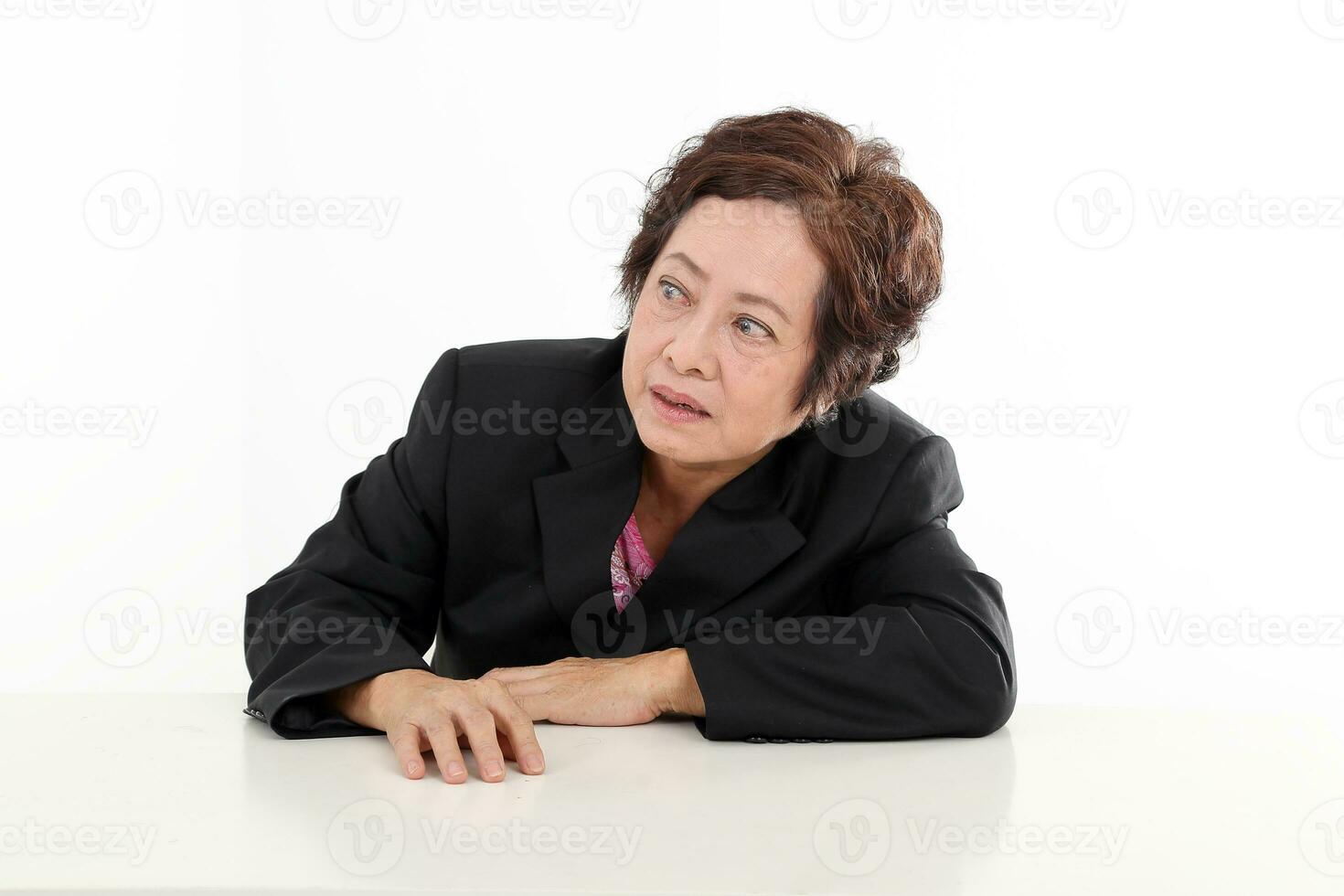 äldre asiatisk kinesisk kvinna på vit bakgrund bär svart kostym se ser observera nyfiken foto