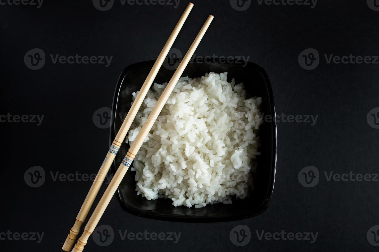 skål med kokt ris på svart bakgrund foto