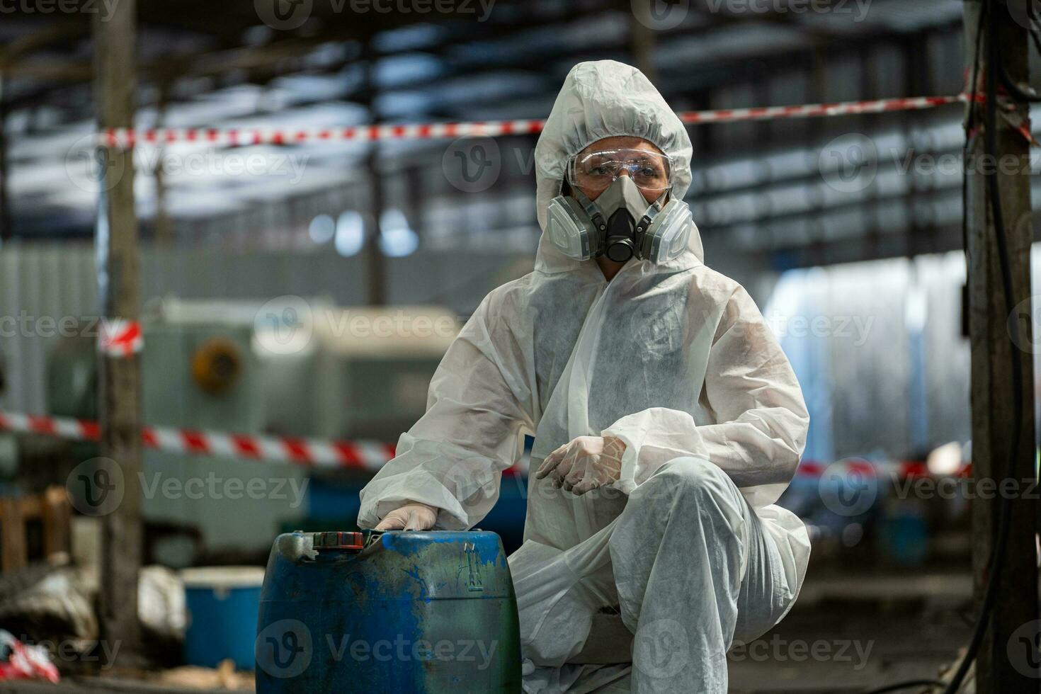 caucasian kvinna arbetare bär ppe skyddande Kläder och gas masker, glasögon, innehav gammal bensin tankar. foto