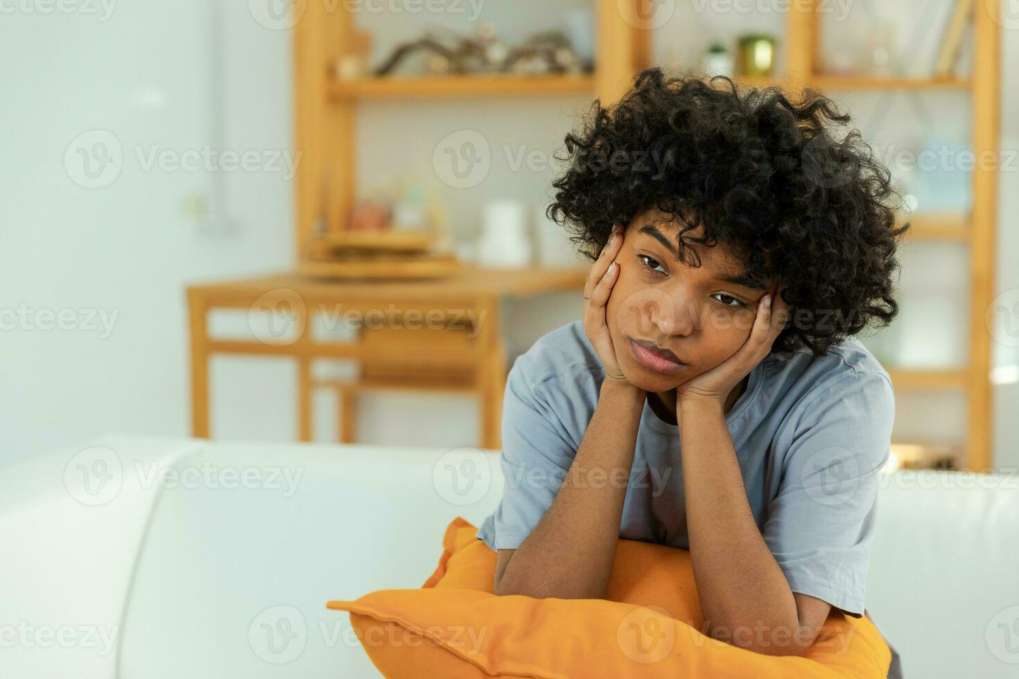 afrikansk amerikan ledsen omtänksam fundersam omotiverad flicka Sammanträde på soffa på Hem inomhus. ung afrikansk kvinna fundera se trött efter lång dag. flicka känner deprimerad stött ensam upprörd sorg. foto