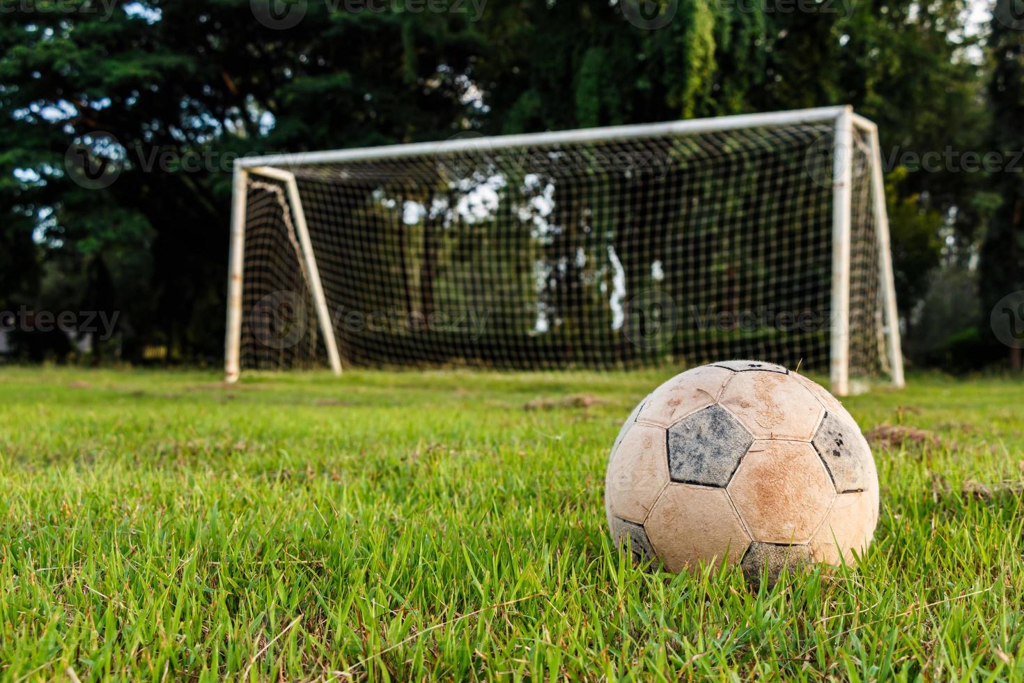 gammal fotboll på gräsmatta i lantlig skola foto