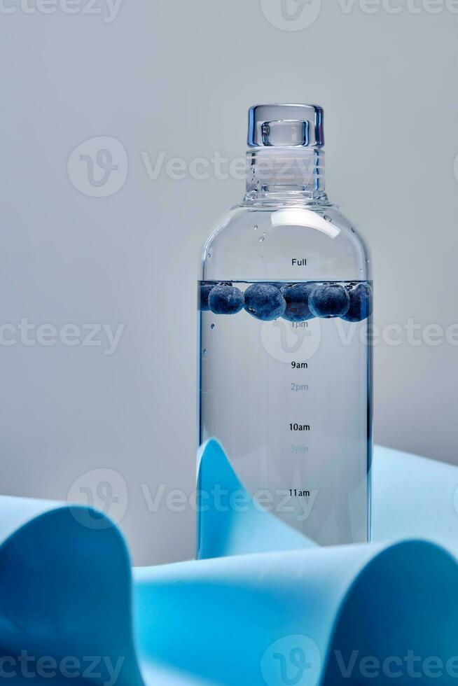 en glas flaska av ren vatten med blåbär. foto