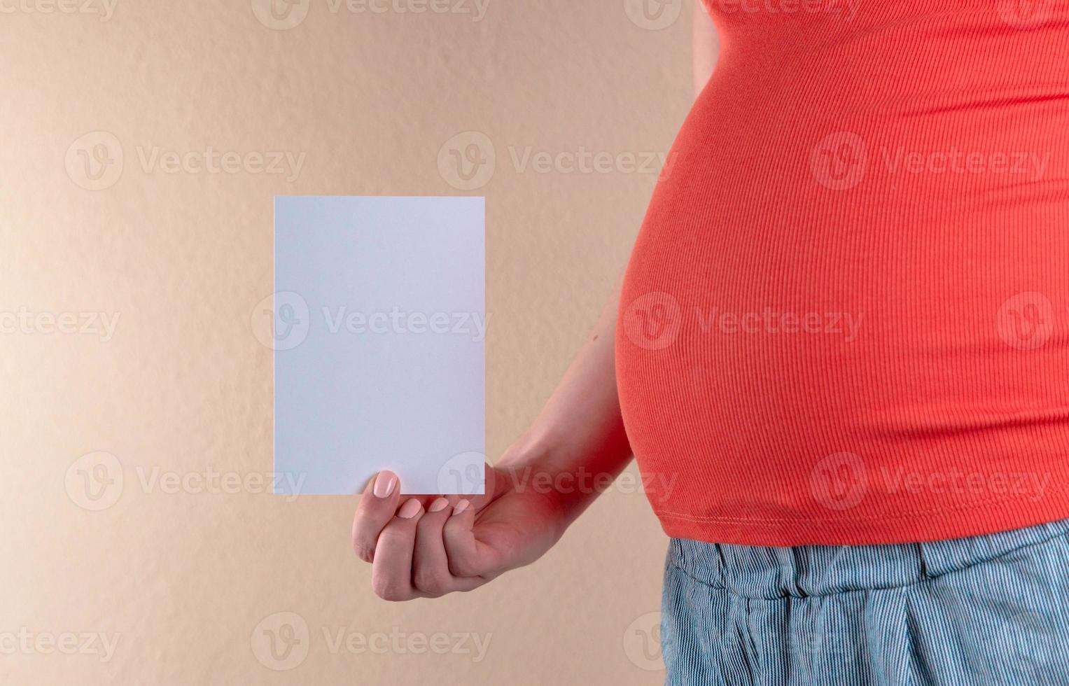 en närbild av magen på en gravid kvinna i rött foto