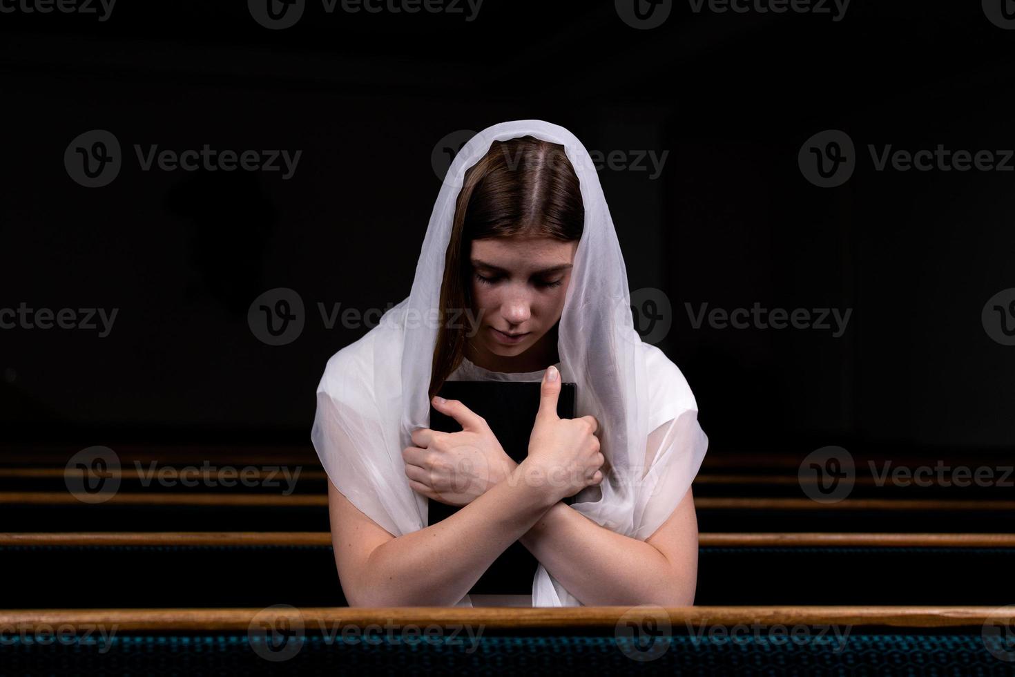 en kristen tjej som ber med ödmjukt hjärta i kyrkan foto