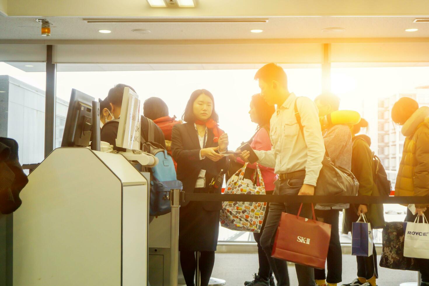 Osaka, japan 2018- turister promenad i linje och visa de pass till flygbolag personal inspektera innan ombordstigning i de terminal av de kansai internationell flygplats. foto