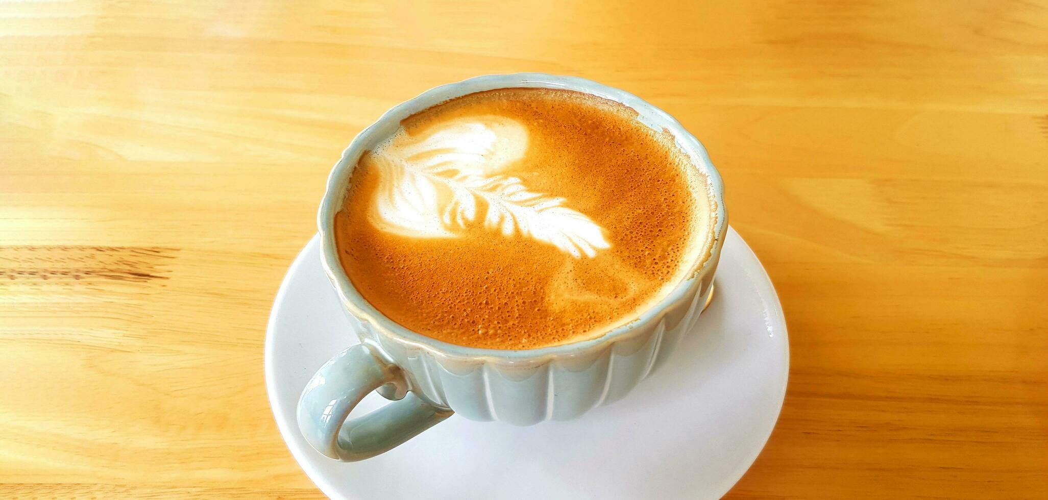stänga upp kopp av konst cappuccino eller latte kaffe isolerat på trä- bakgrund eller tabell på Kafé affär. varm dricka i glas med kopia Plats. mat design begrepp. foto