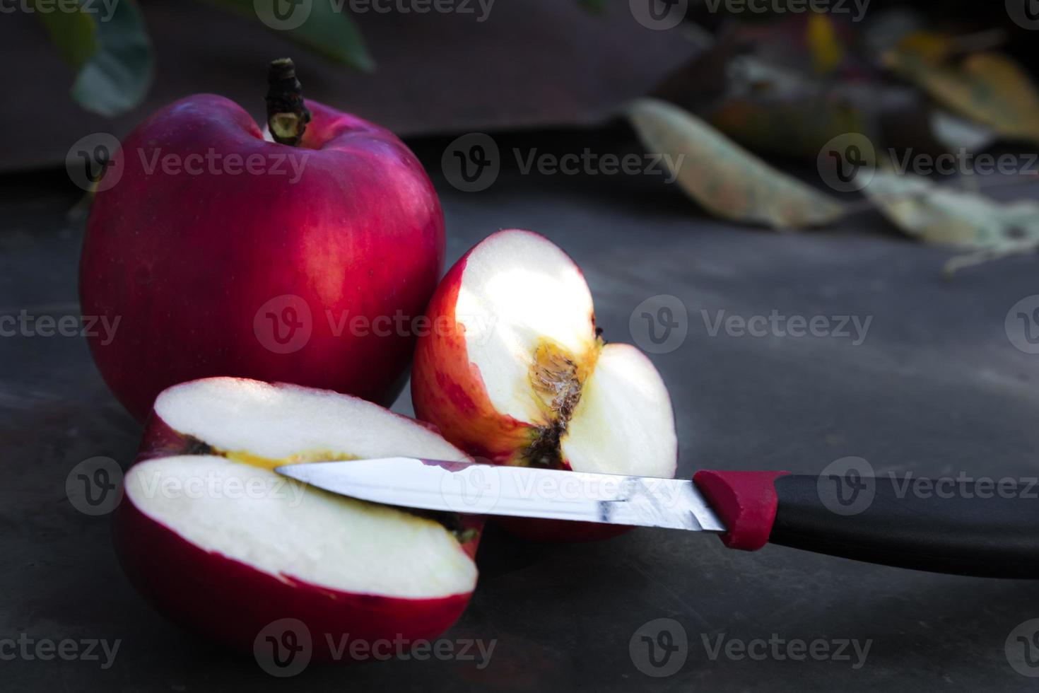 närbild av ett skivat rött äpple på ett träbord foto