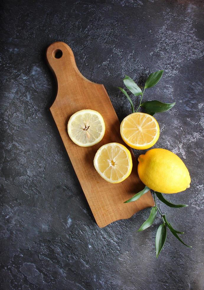 citroner och gröna blad på ljus svart bakgrund foto