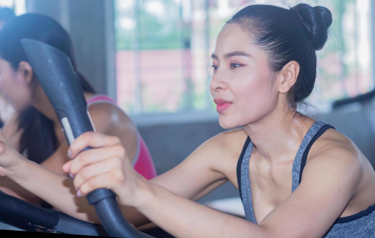 kvinnan tränar i gymmet med ett lyckligt leende ansikte foto