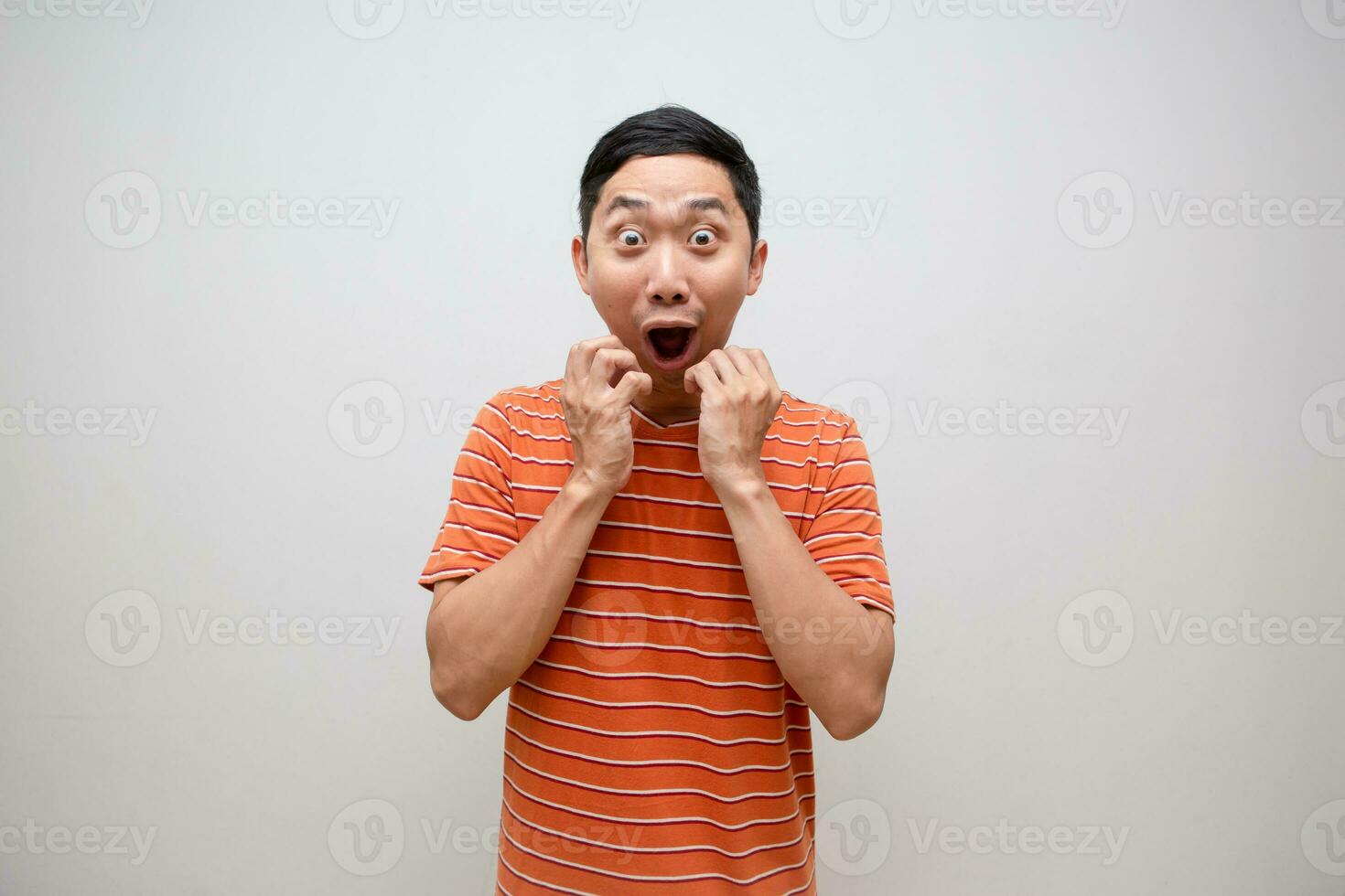 asiatisk man orange skjorta känner upphetsad chockade ansikte isolerat foto