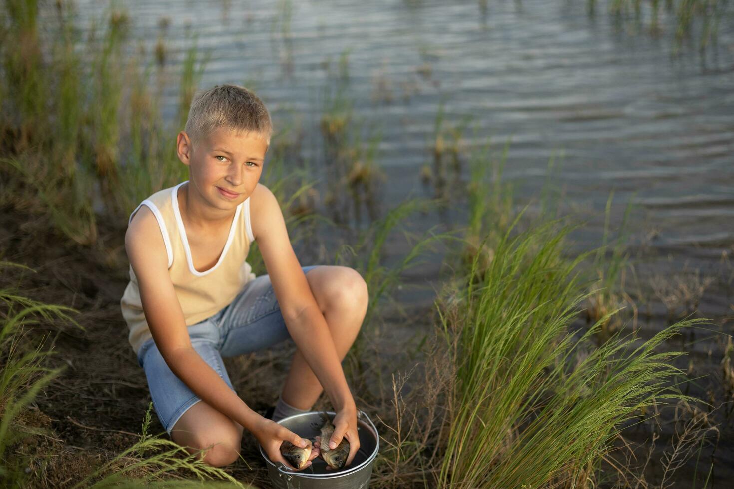liten pojke är fiske på solnedgång på de sjö. sommar högtider i en by. resten i natur, bort från de stad foto