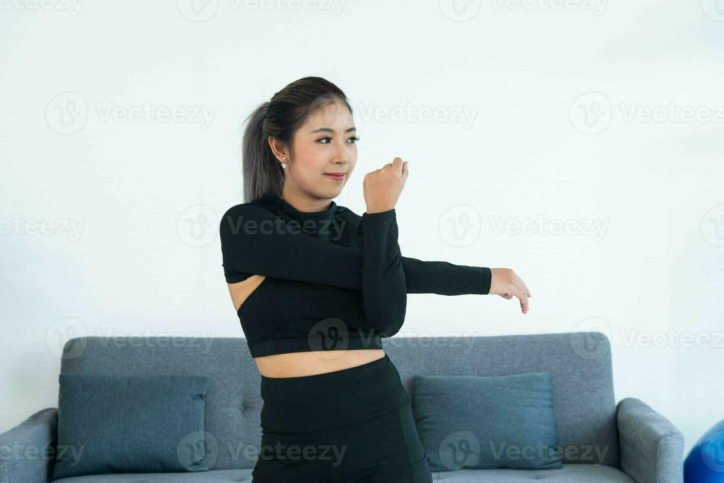 asiatisk ung friska kvinna i sportartiklar praktiserande yoga på Hem, sport flicka övning i levande rum på Hem foto