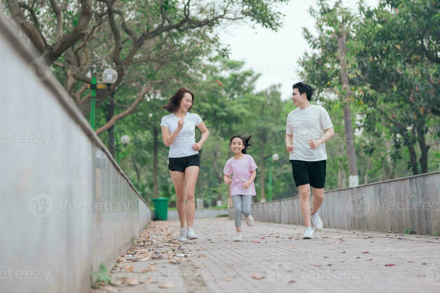 Foto av ung asiatisk familj övning på parkera