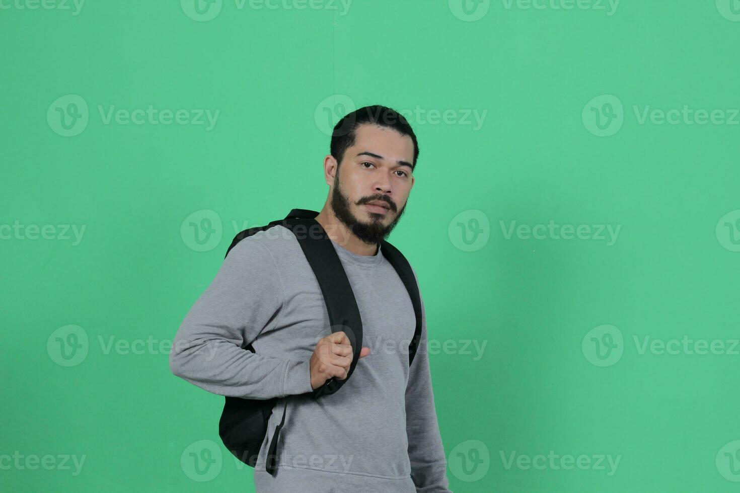 skäggig asiatisk studerande uttryck använder sig av ryggsäck foto