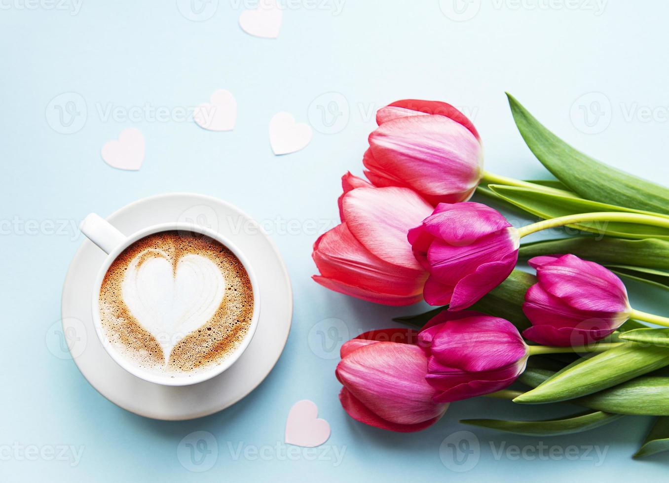 kaffekopp med lattekonst och tulpaner foto