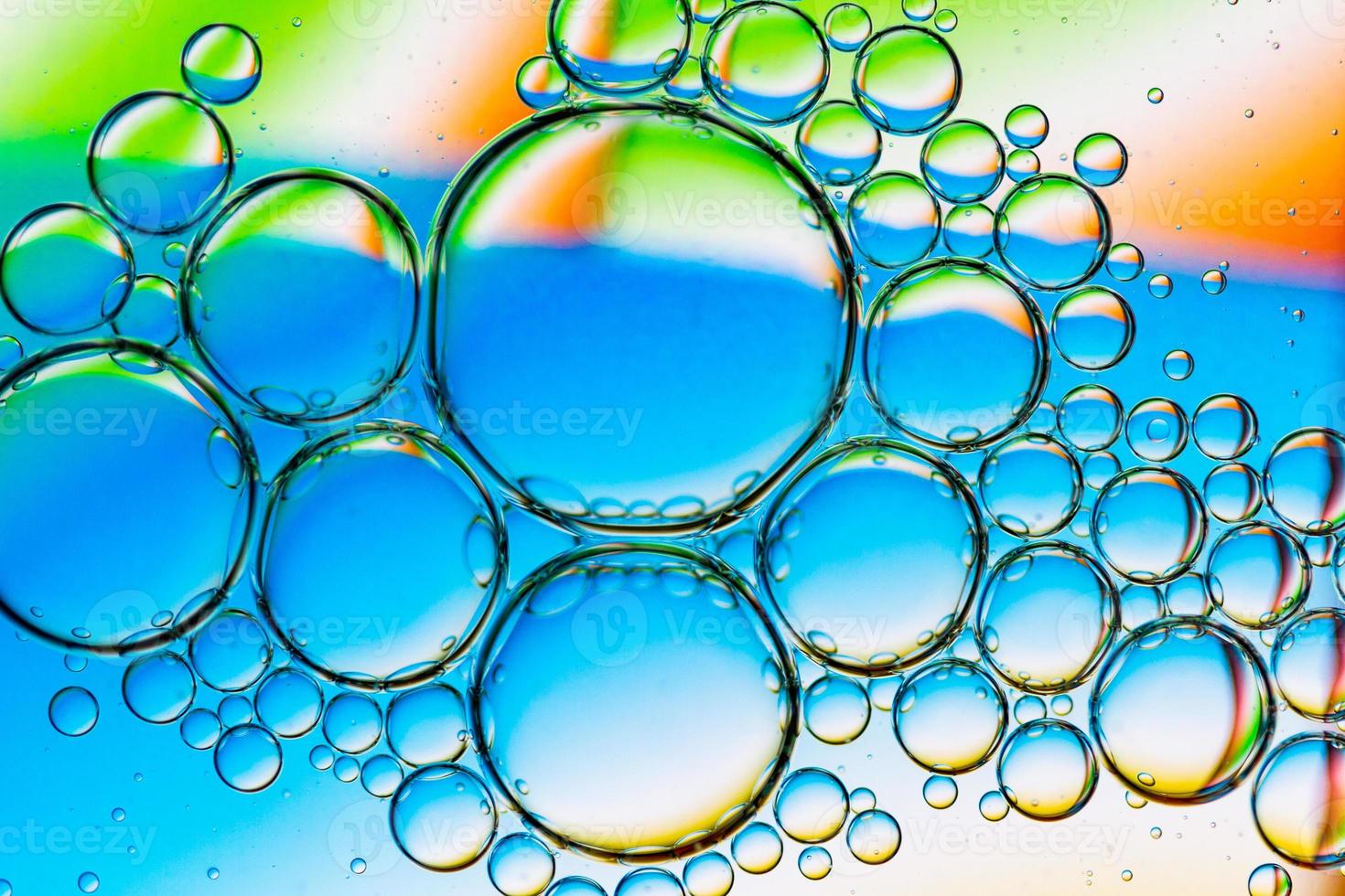 abstrakt bakgrund av oljebubblor på vattenytan cyan orange grön färgglad palett foto
